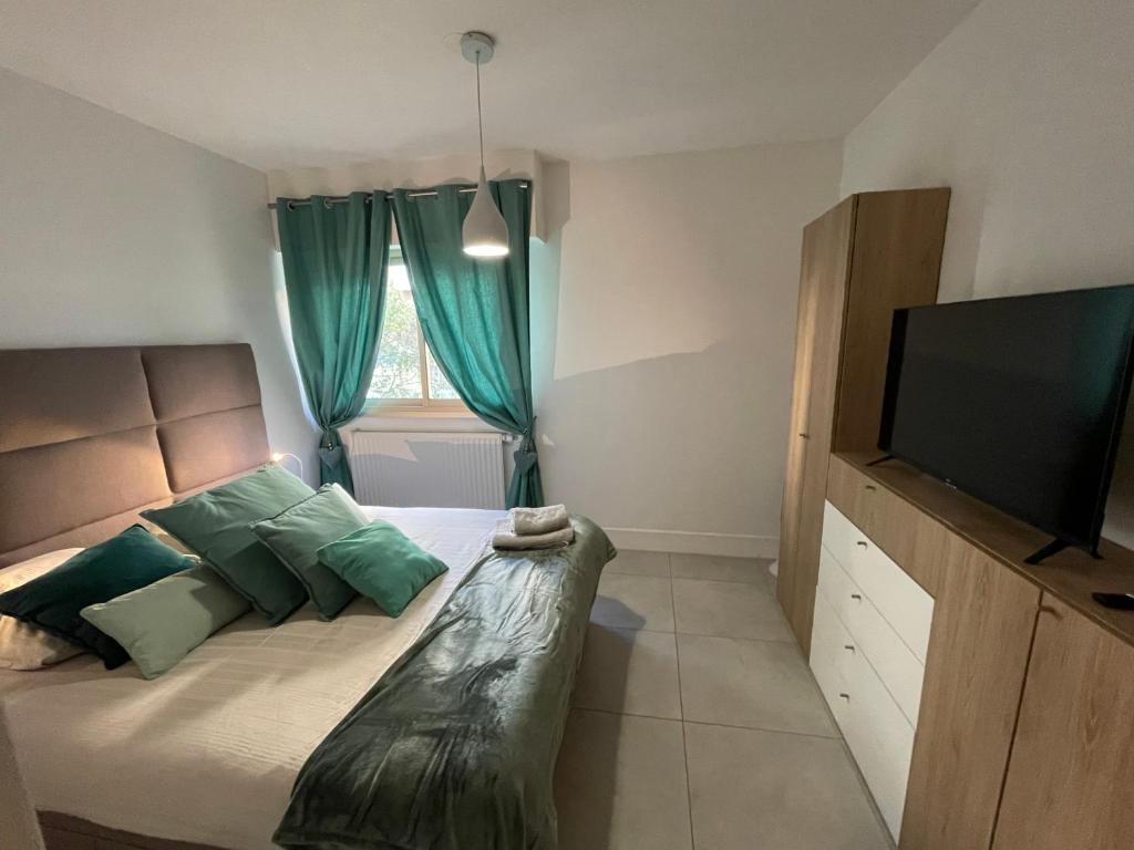 1 dormitorio con 1 cama y TV de pantalla plana en Le Melody, en Antibes