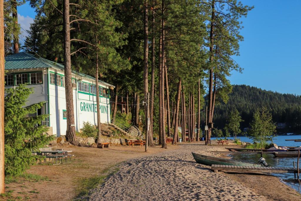 a building on the shore of a lake with trees at Granite Point Resort in Loon Lake