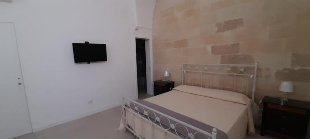 sypialnia z łóżkiem i telewizorem z płaskim ekranem w obiekcie casa vacanze Laura s/c w mieście Lecce