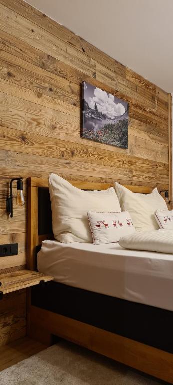 ein Schlafzimmer mit einer Holzwand und 2 Betten in der Unterkunft Frühstückspension Bachseitenhof in Radstadt