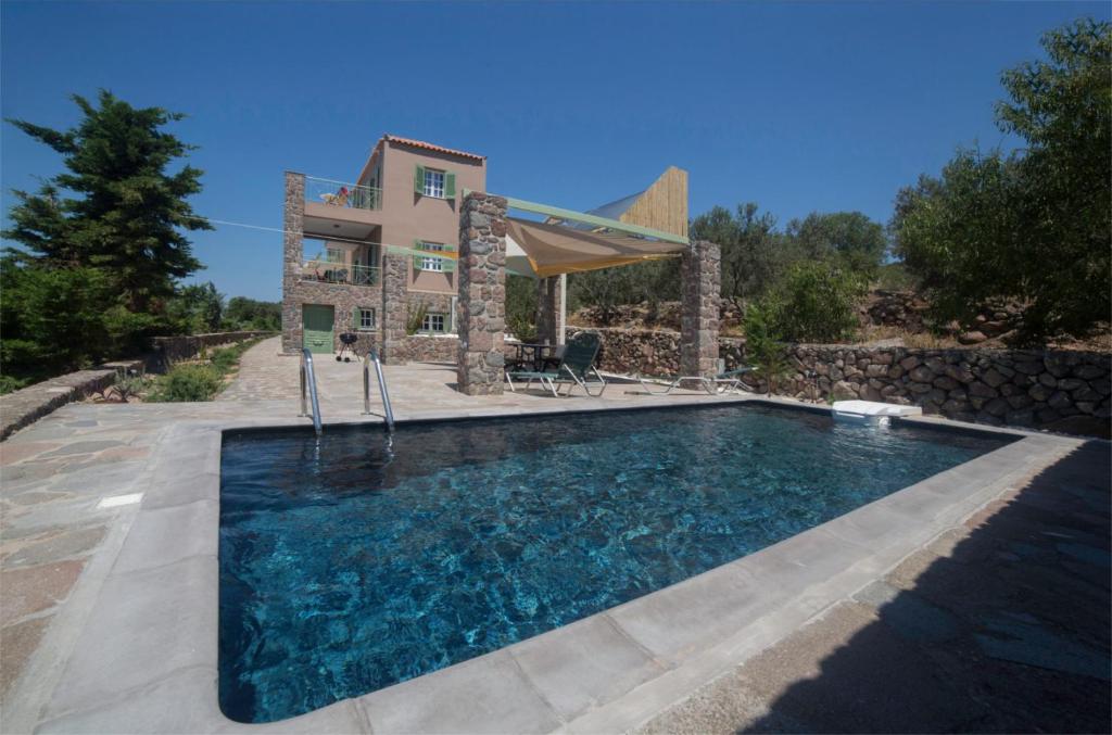 a villa with a swimming pool in front of a house at Villa Cerise by Upgreat Hospitality in Egina