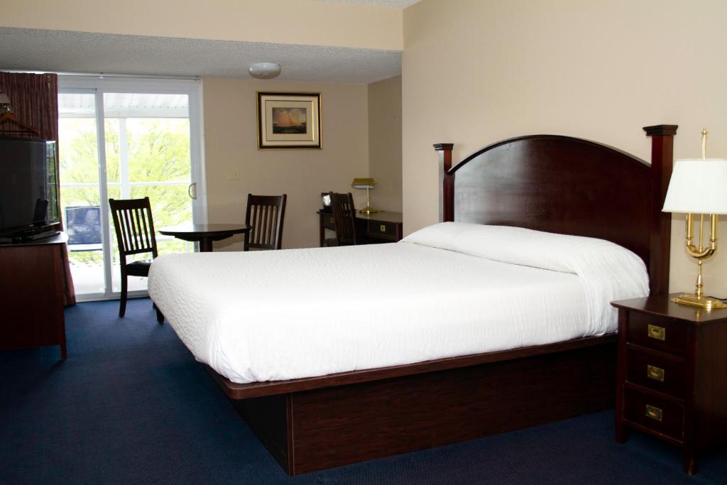 a bedroom with a large bed and a balcony at The Anchor Inn in Watkins Glen