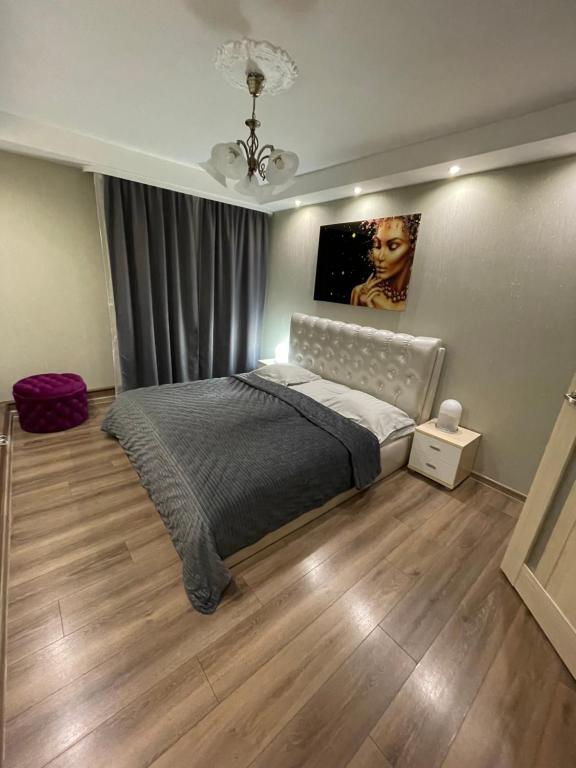 um quarto com uma cama e um quadro na parede em K.G. Apartment em Ventspils