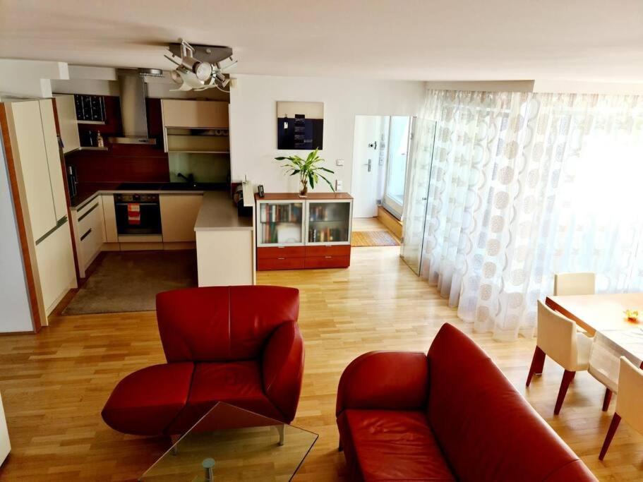a living room with a red chair and a table at luxury 4 bedroom roof apt with 3 balconies & view in Vienna