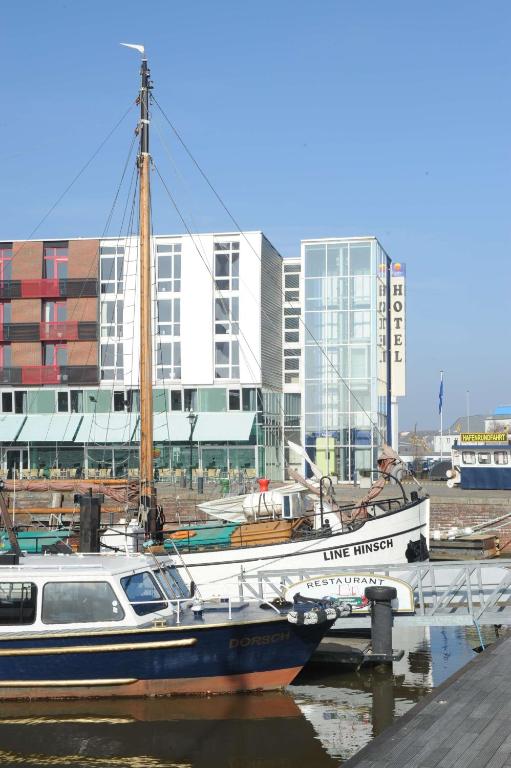 a boat docked at a marina with buildings in the background at Nordsee Hotel Fischereihafen in Bremerhaven