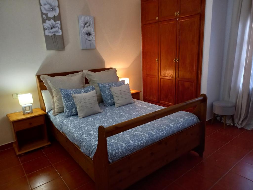 um quarto com uma cama com almofadas azuis e brancas em Casa Ramos em Arrecife