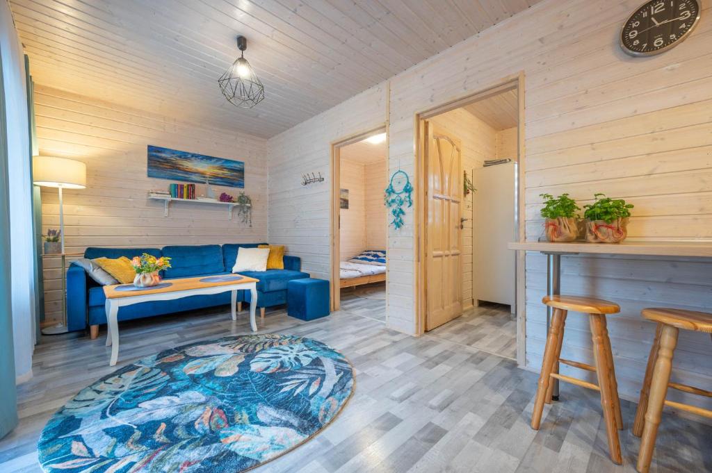 a living room with a blue couch and a table at Domki letniskowe Alma, Jarosławiec in Jarosławiec