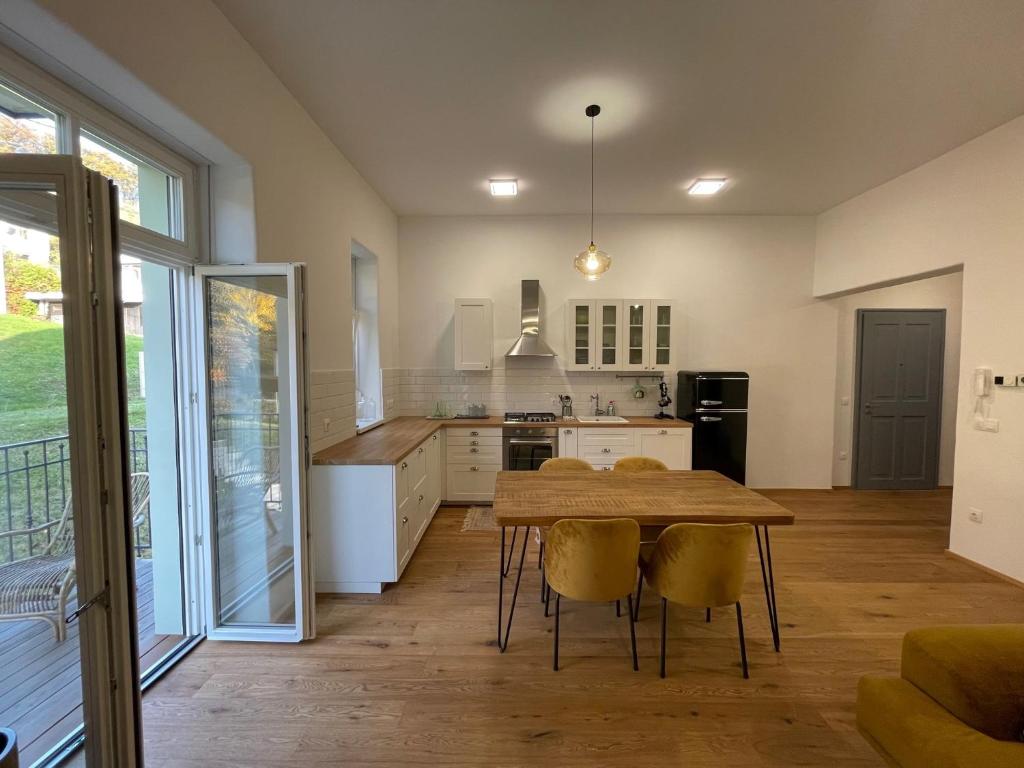 a kitchen with a wooden table and yellow chairs at Ipavčeva vila in Maribor