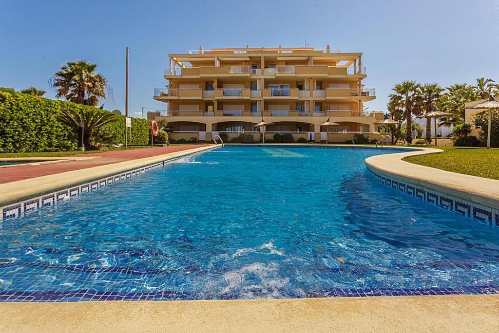 uma grande piscina em frente a um edifício em urbanización Catamaran em Denia