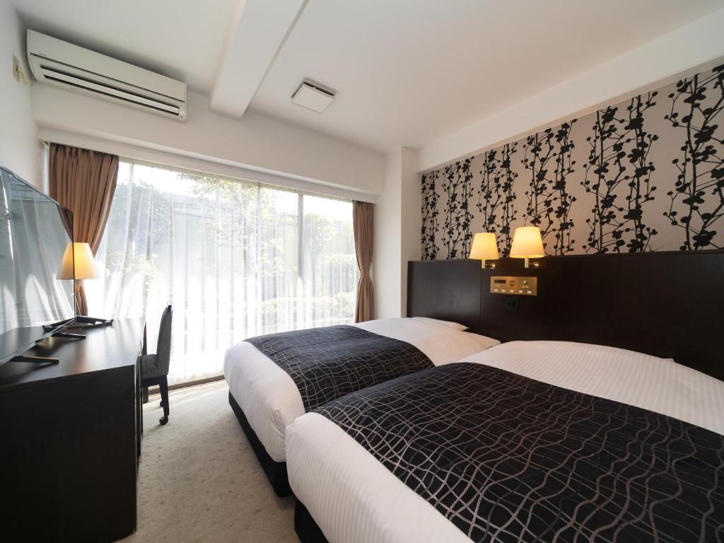 Postel nebo postele na pokoji v ubytování APA Hotel Osaka Kadomashi Ekimae