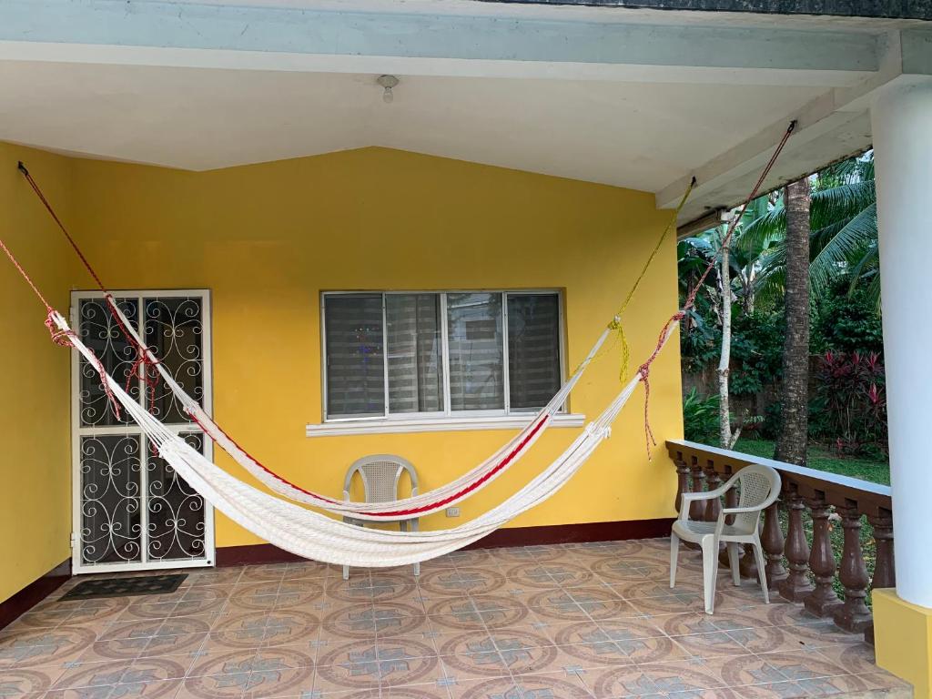 a hammock hanging from a yellow house at Casa Verónica a 2 kilometros del IRTRA in Retalhuleu