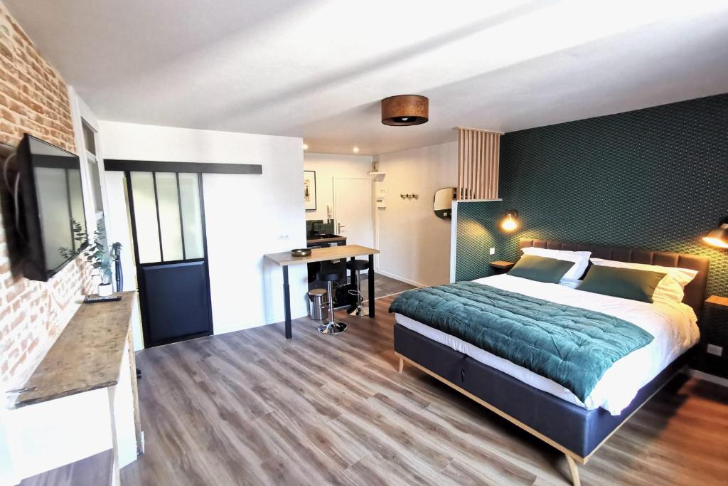 a bedroom with a bed and a desk in a room at Appart de charme Hyper-centre LIMOGES ! in Limoges