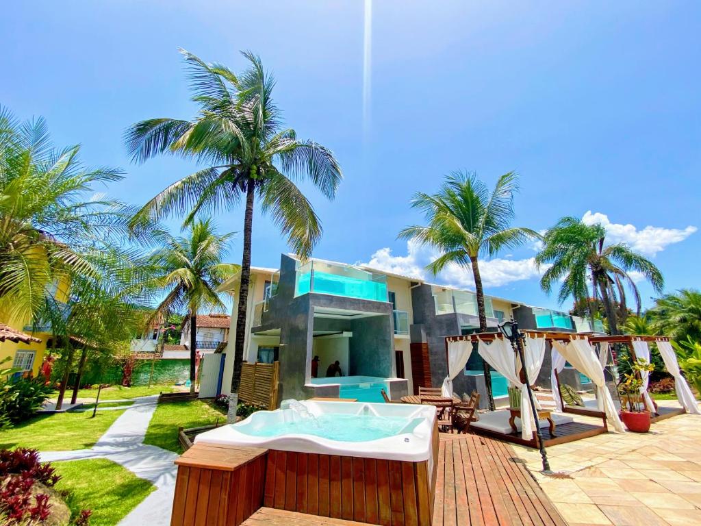 Pousada Villa del Sol في باراتي: منزل به مسبح وحوض استحمام ساخن