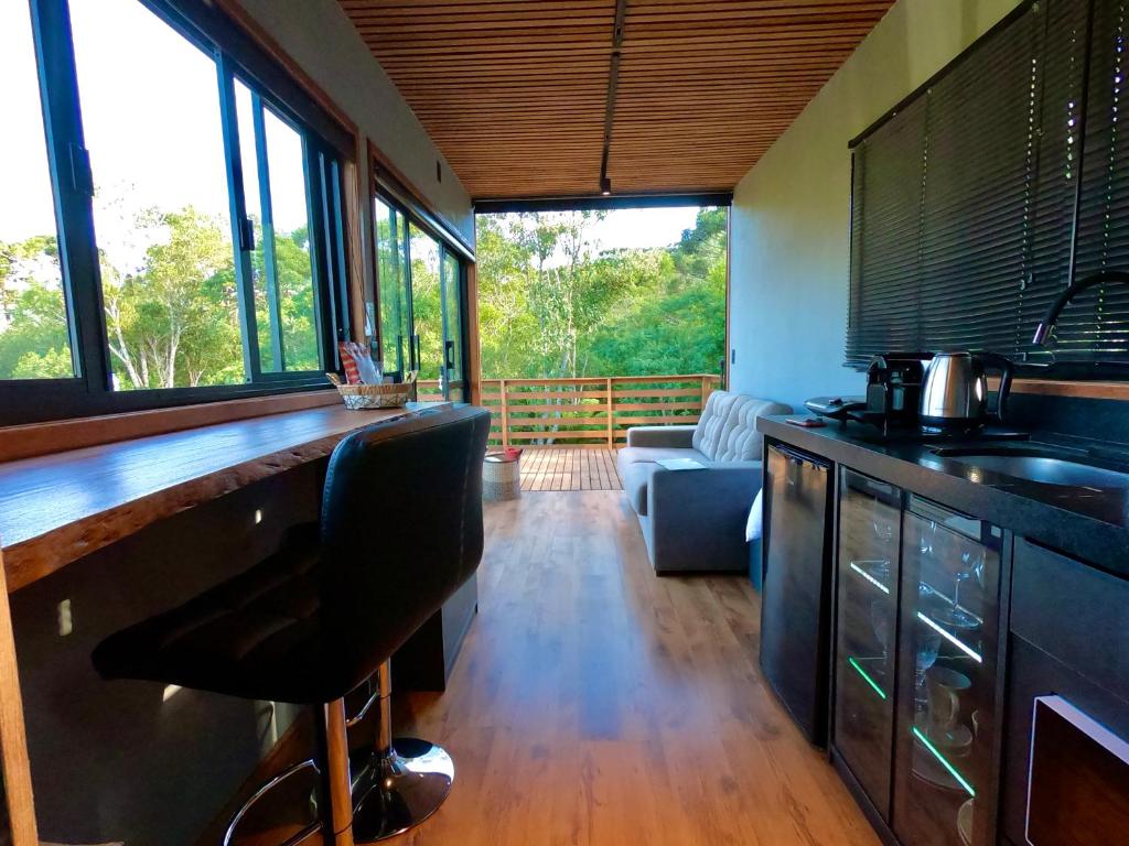 a kitchen with a bar with a counter top at Tinyhouse da Floresta in Urubici