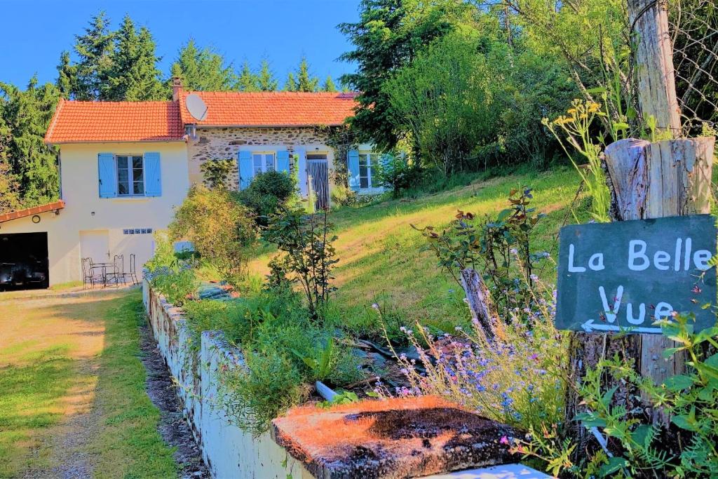 une maison avec un panneau devant une cour dans l'établissement La Belle Vue - Coin de paradis, à Sussac