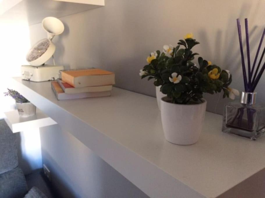 un comptoir blanc avec un vase de fleurs et de livres dans l'établissement Bonito apartamento en Granada (zona palacio congresos y metro), à Grenade