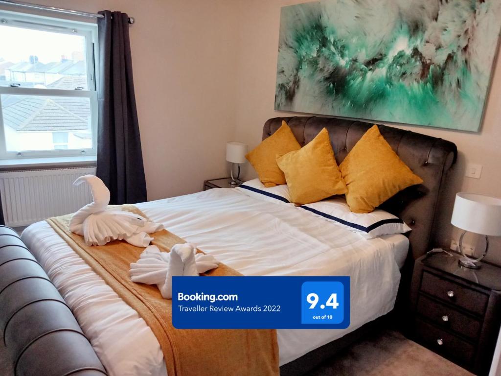 1 dormitorio con 1 cama con almohadas amarillas en Glorious Duplex Holiday Apartment By The Sea en Bognor Regis