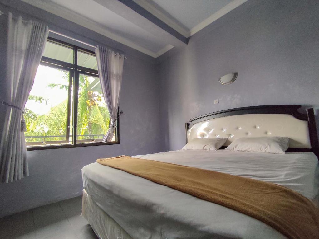 Un dormitorio con una cama grande y una ventana en Wisma Tulus Syariah Kebumen Mitra RedDoorz, en Kebumen