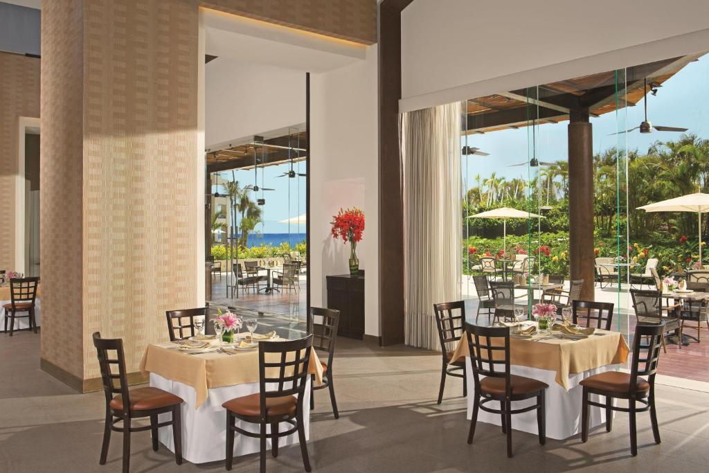 a restaurant with tables and chairs with a view of the ocean at Secrets Vallarta Bay Resort & SPA - Adults Only in Puerto Vallarta
