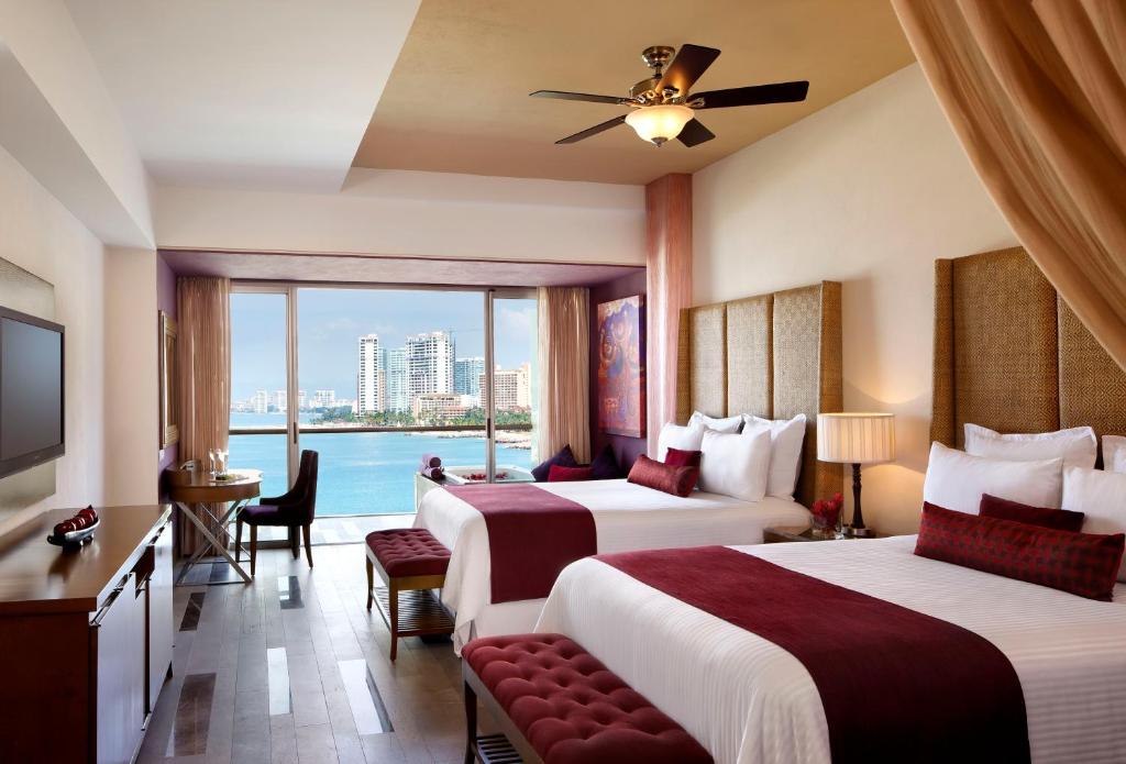 a hotel room with two beds and a balcony at Secrets Vallarta Bay Resort & SPA - Adults Only in Puerto Vallarta