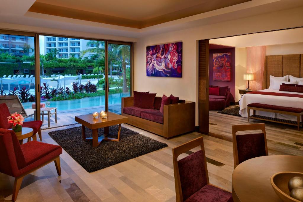 a hotel room with a bed and a living room at Secrets Vallarta Bay Resort & SPA - Adults Only in Puerto Vallarta