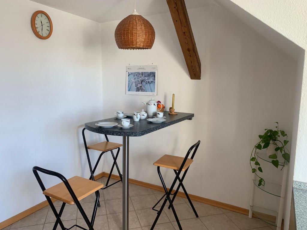 a table in a room with two chairs and a clock at Biesdorf-verkehrsgünstig und ruhig in Berlin