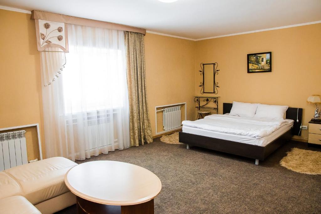 LeninogorskにあるHotel Akvamarinのベッド、ソファ、テーブルが備わる客室です。