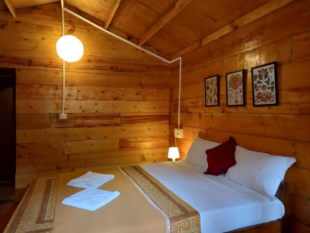 a bedroom with a bed in a log cabin at Cilantro Agonda in Agonda