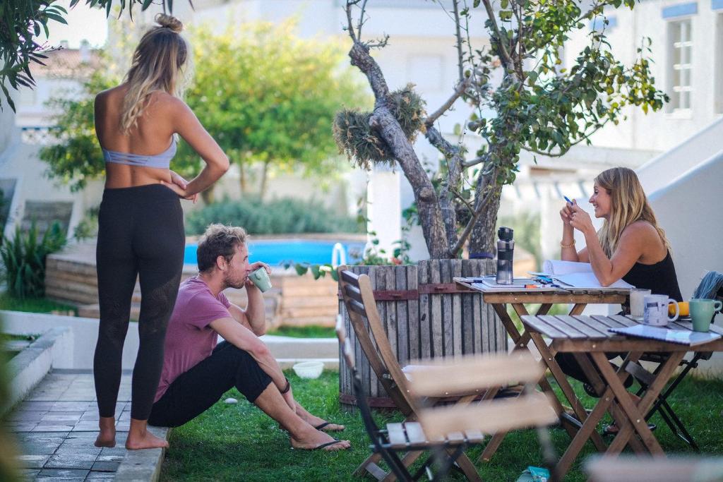 Un groupe de personnes assises autour d'une table dans une cour dans l'établissement Olive3 Ericeira, à Ericeira