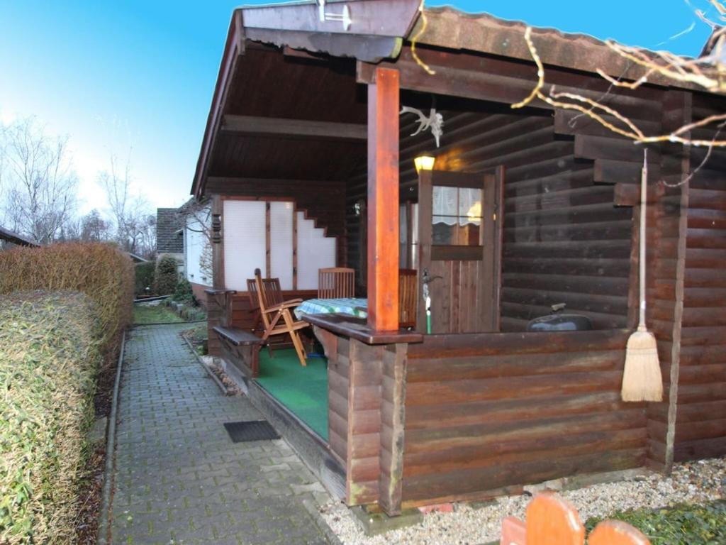 a small wooden cabin with a porch and a patio at Blockhouse Spreewald, Alt Zauche in Alt Zauche