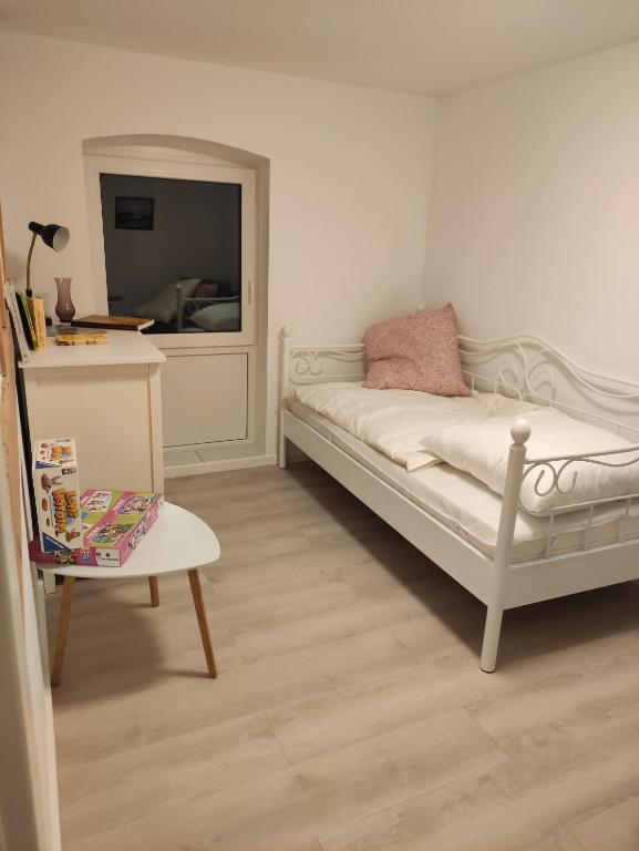 a bedroom with a bed and a table and a mirror at Ferienwohnung auf dem Pferdehof in Sumte