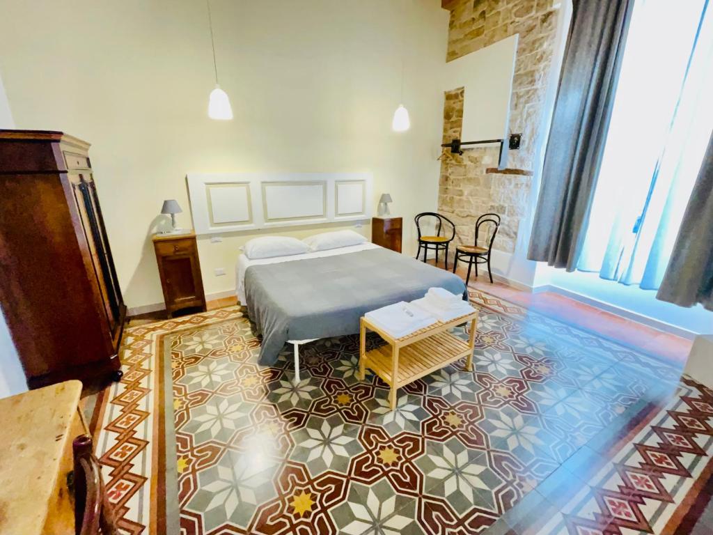 een slaapkamer met een bed en een tapijt bij Palazzo Lupicini Affittacamere in Bisceglie