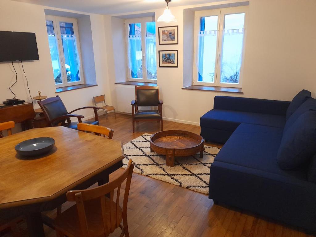 - un salon avec un canapé bleu et une table dans l'établissement La maison du Sotré, à Raon-sur-Plaine