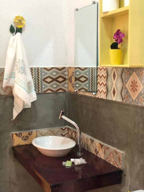 a bathroom with a bowl sink on a wooden counter at Villa da Serra Pousada in Piumhi