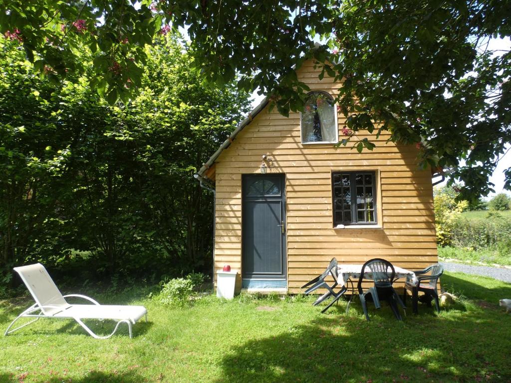 une maison avec une table et des chaises devant dans l'établissement Le chalet de la Ferme Feugère, à Barbeville