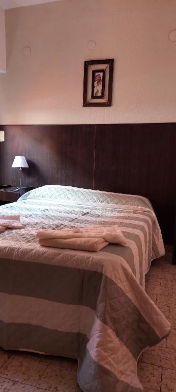 a bedroom with a large bed with a wooden headboard at Gran Continente Santa Teresita in Santa Teresita