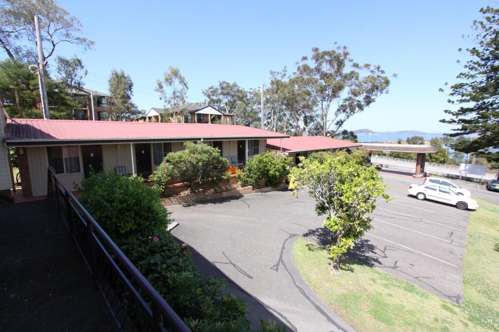 a building with a car parked in a parking lot at Waterview Gosford Motor Inn in Gosford