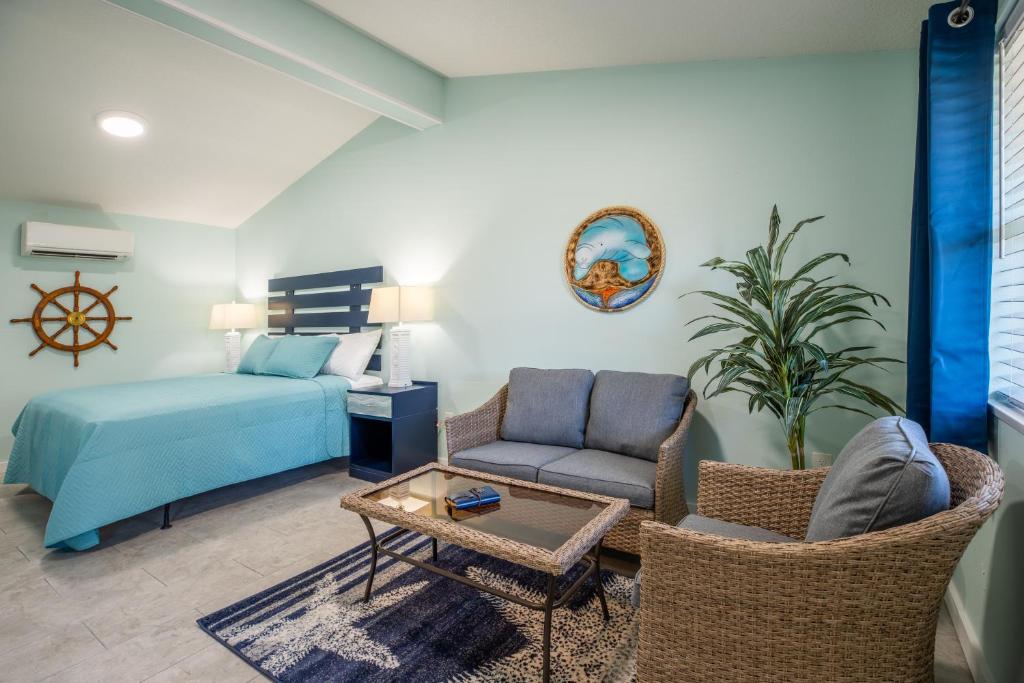a living room with a bed and a couch at Salt Air Inn & Suites in Atlantic Beach
