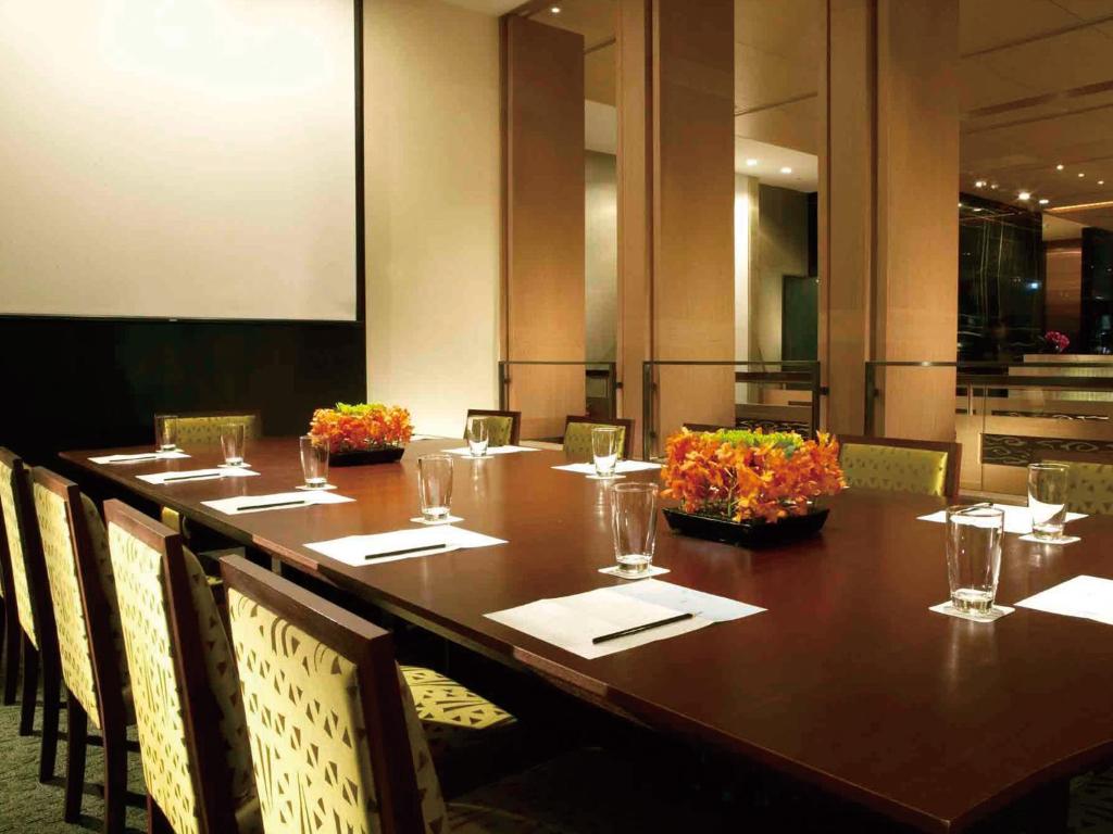 a long table with chairs and a long table with glasses at City Suites-Taipei Nanxi in Taipei