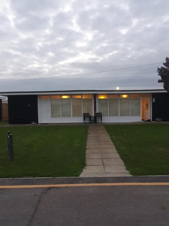 a building with a bench in front of it at Grand Chalet 64 Disabled Friendly in Skegness