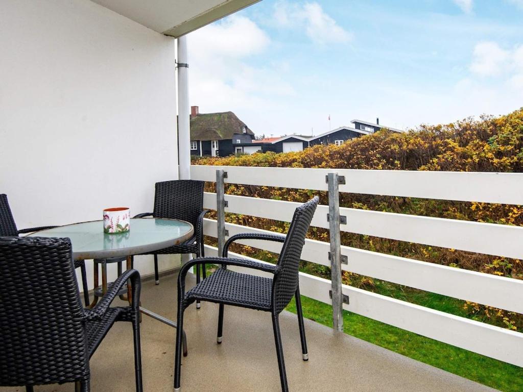 d'une table et de chaises sur un balcon avec vue sur l'océan. dans l'établissement Holiday home Ringkøbing LXXII, à Ringkøbing