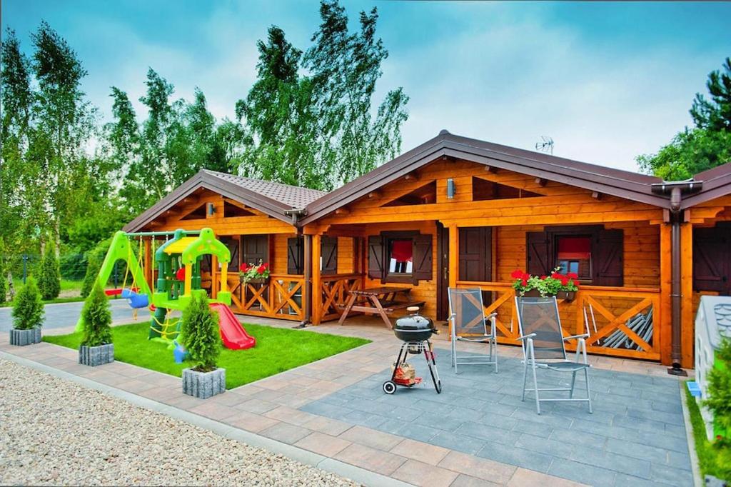 a log cabin with a playground in front of it at Row bungalows, Sianozety in Sianozety