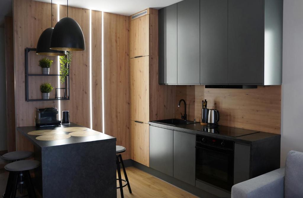 a kitchen with black cabinets and a counter top at Apartamenty METRO TARGÓWEK 27 in Warsaw