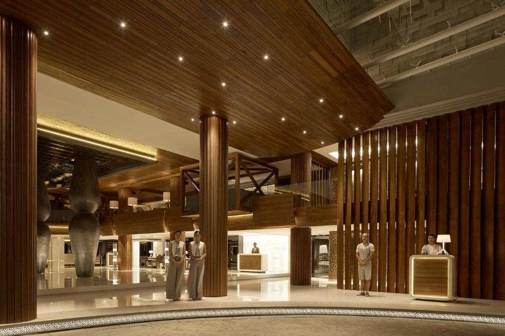 a lobby with a man standing in the middle of a building at Double - Six, Luxury Hotel - Seminyak in Seminyak