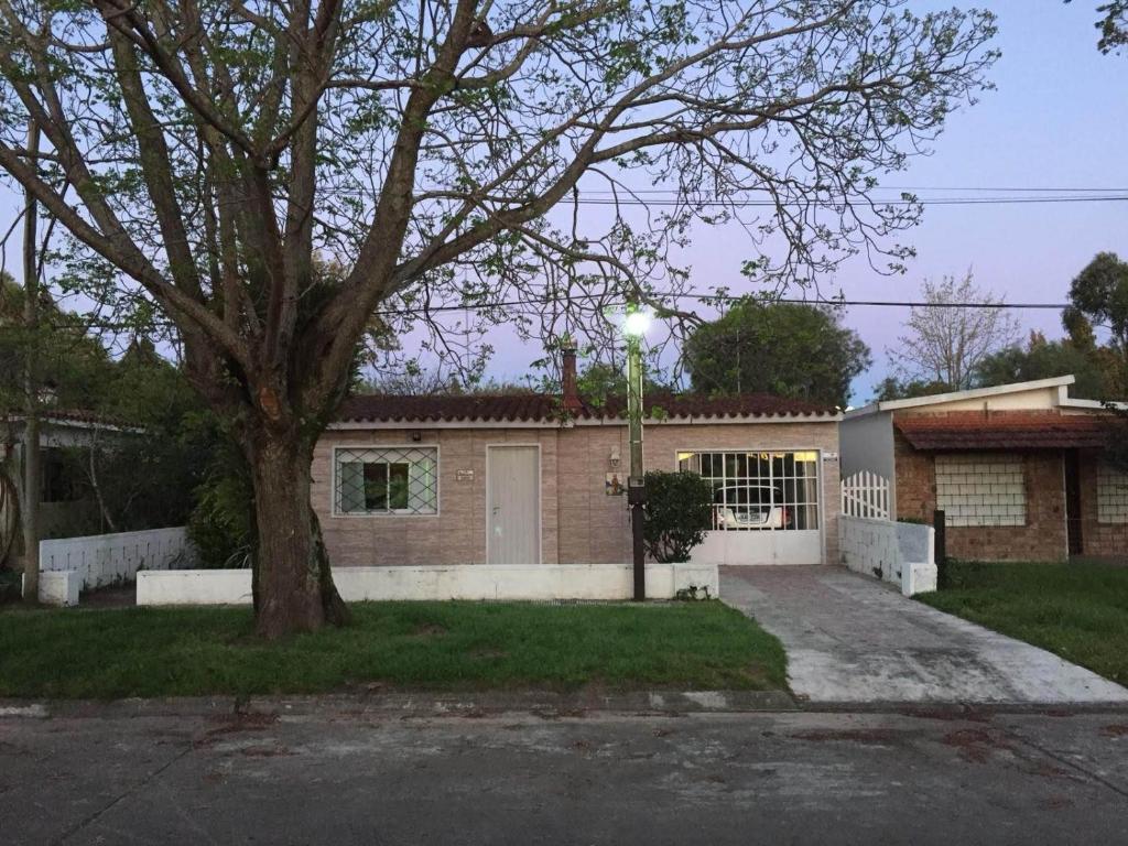 uma casa com uma árvore em frente em Martin Fierro em La Floresta