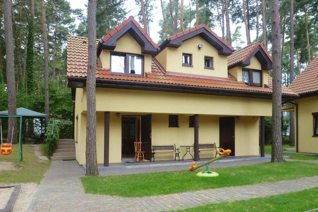 a yellow house with a baseball bat in the yard at Cozy apartments for 2 people, Pobierowo in Pobierowo