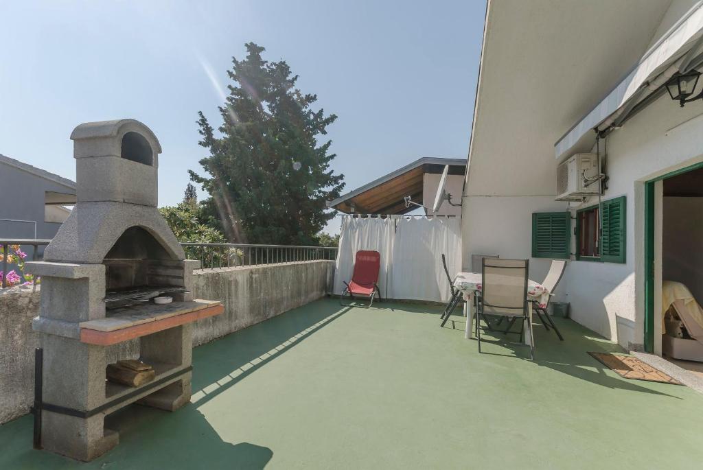 a outdoor patio with a pizza oven in a house at Apartments Romic in Jadrija