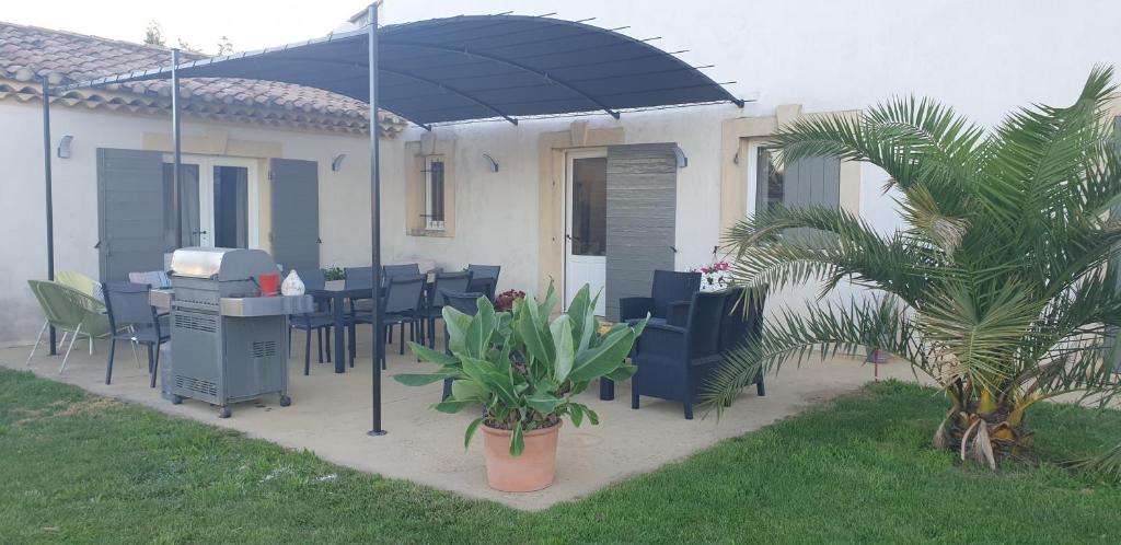 une terrasse avec une table, des chaises et un parasol dans l'établissement Villa avec piscine 14 couchages, à Charleval