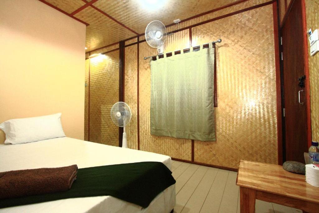 a bedroom with a bed and a window with a curtain at Beck's Resort in Haad Pleayleam