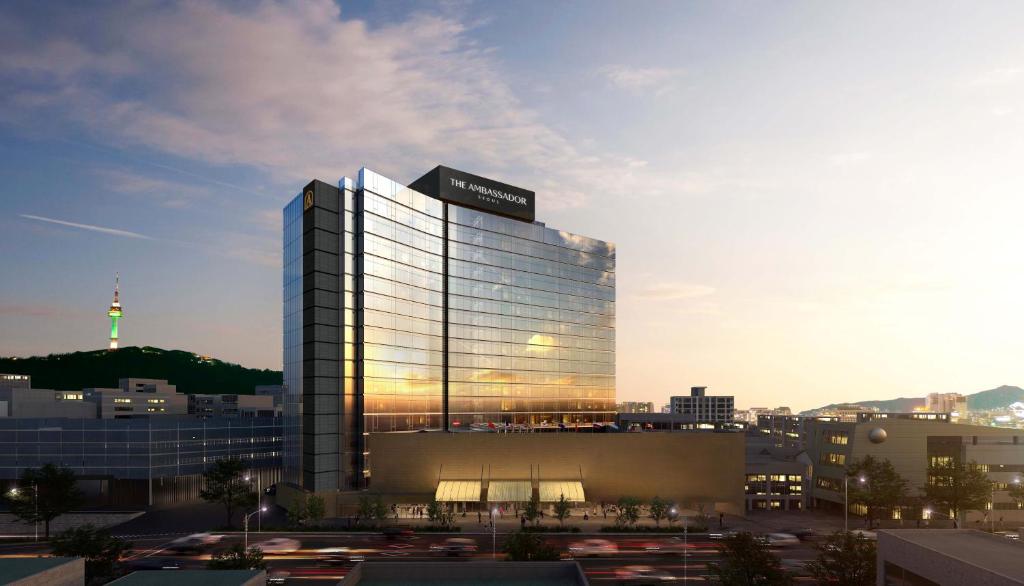 un grand bâtiment en verre avec un panneau en haut dans l'établissement The Ambassador Seoul - A Pullman Hotel, à Séoul